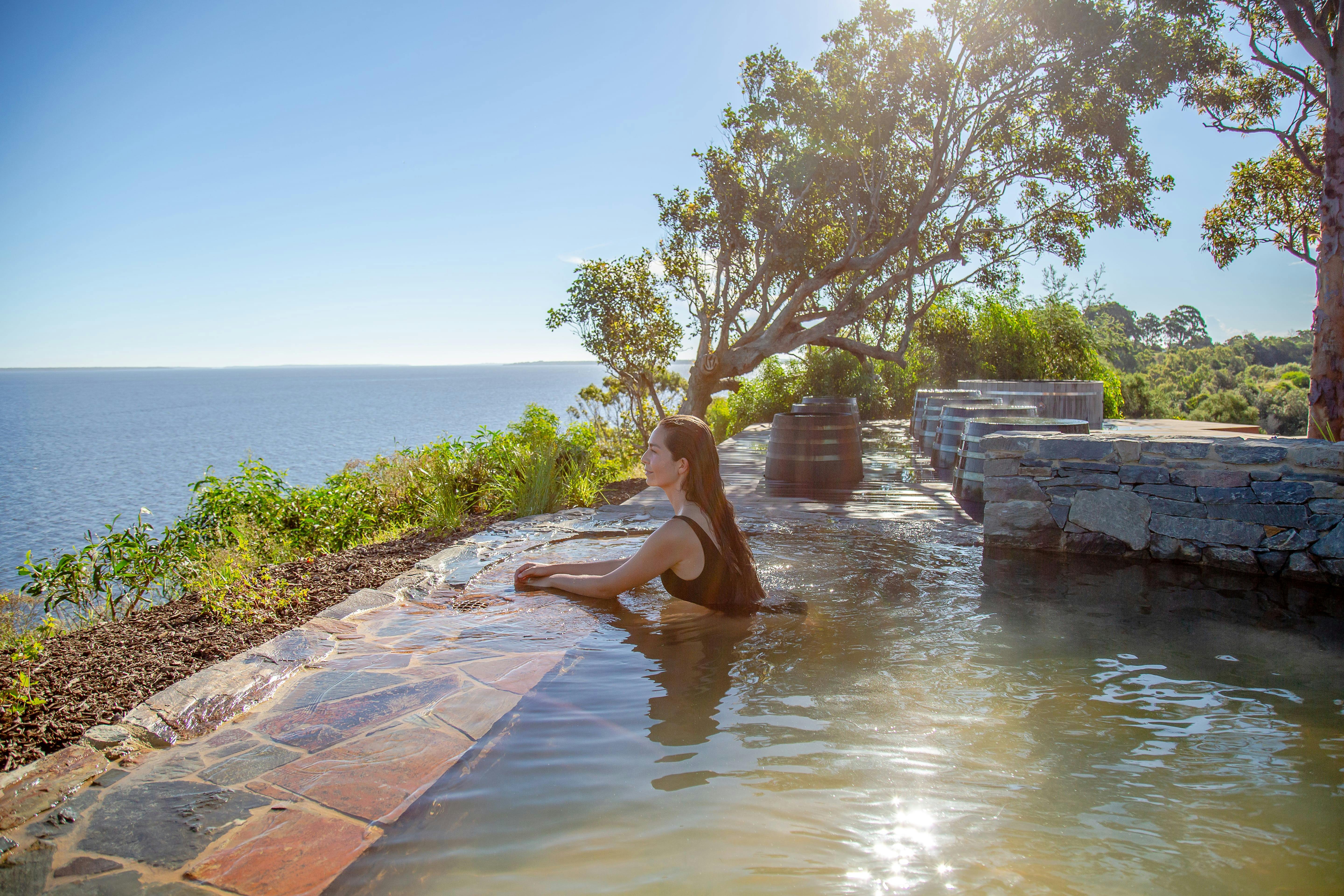 Lady sitting in thermal pool overlooking the lakes