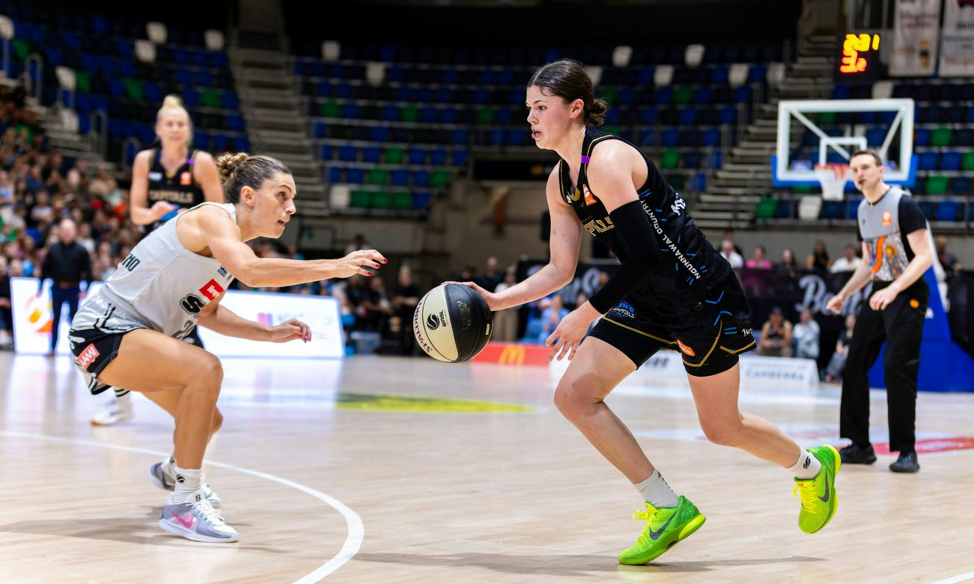 UC Capitals player driving to the basket for a layup during a WNBL game.