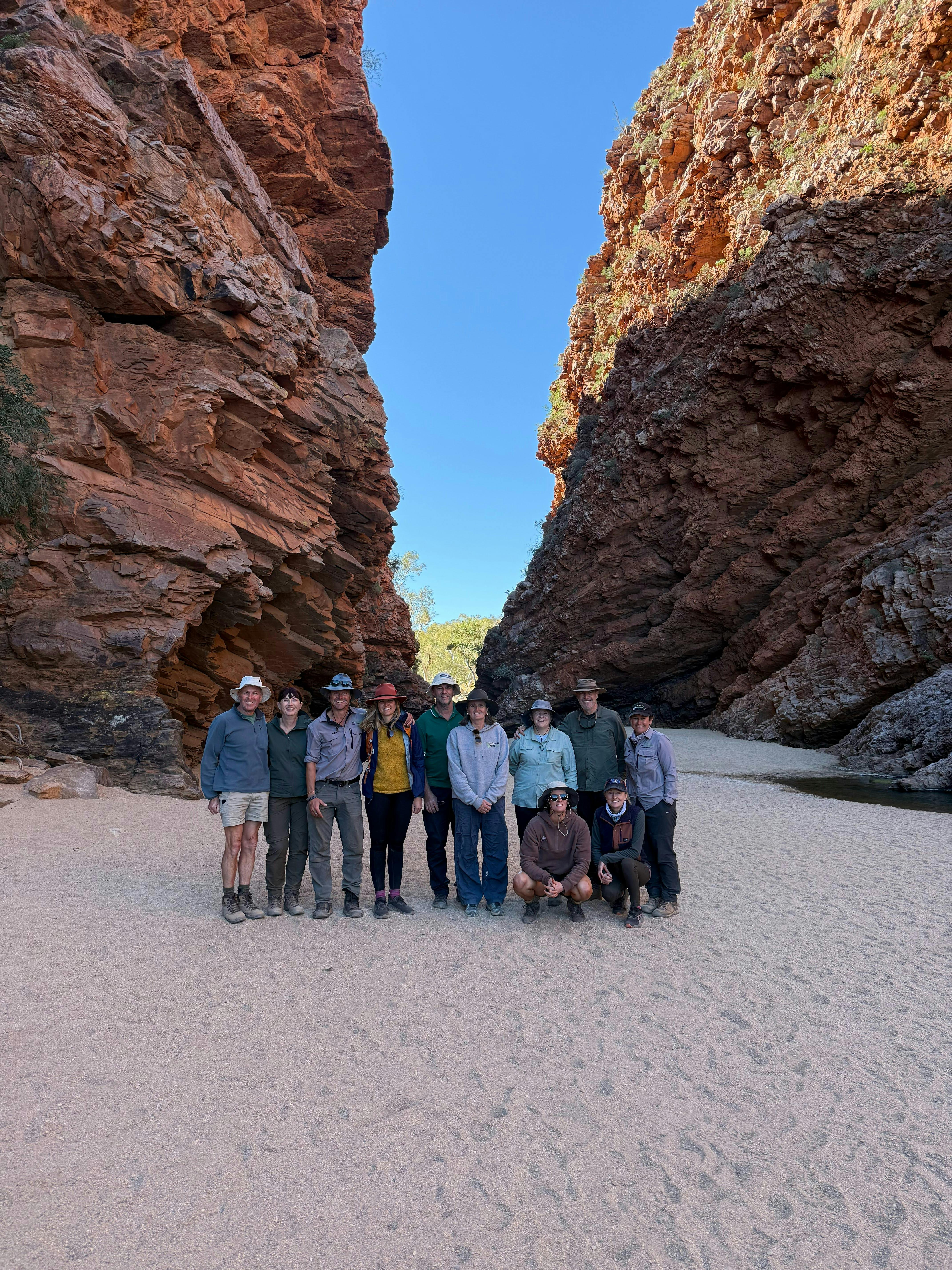 Group of walkers in a red rock gorge on the Larapinta Trail Northern Territory guided walking tour
