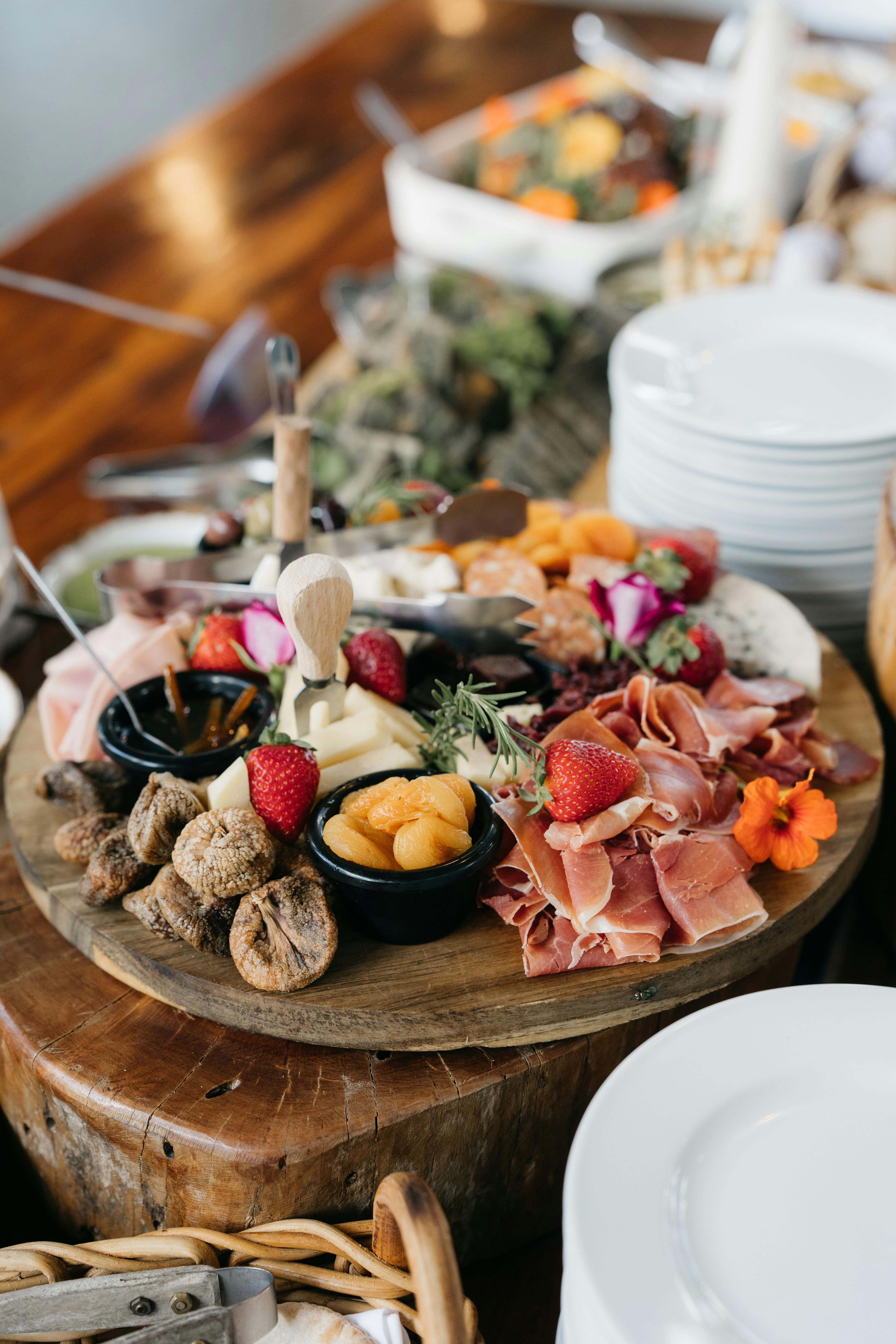 Colourful Charcuterie board with cured meats, dried fruits, strawberries and dips for Fathers Day