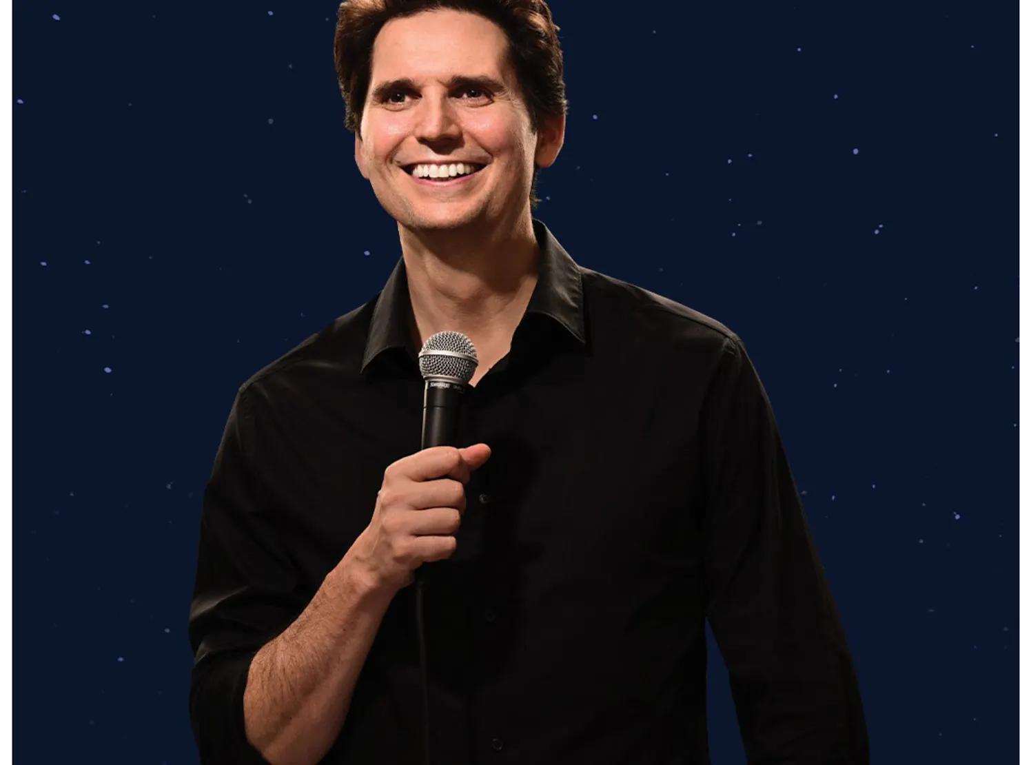 portrait of Joel with a microphone near his mouth