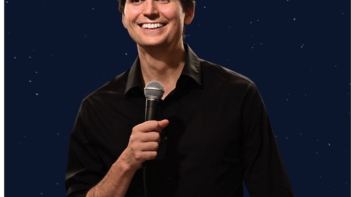 portrait of Joel with a microphone near his mouth