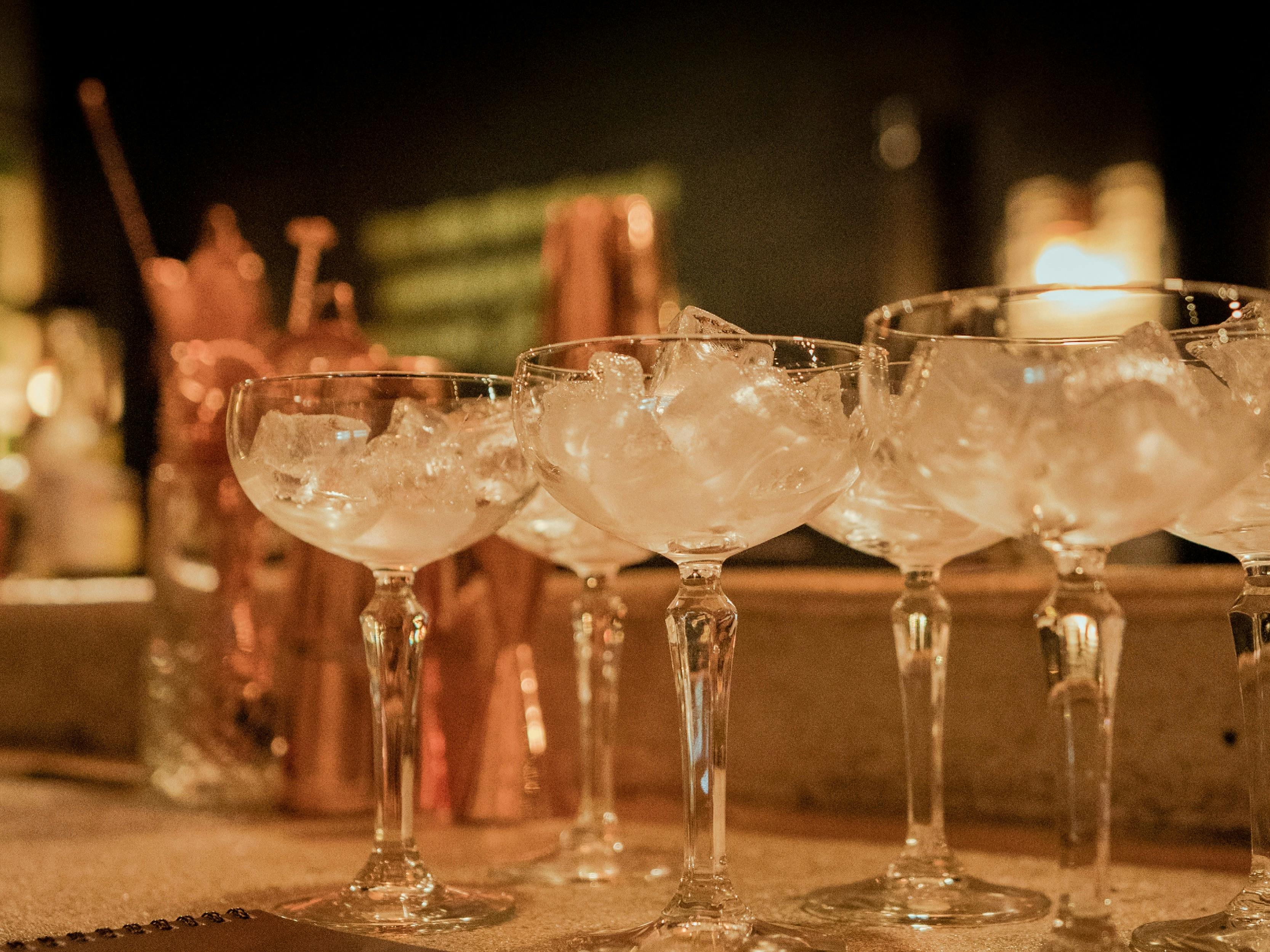 Cocktail coupe glasses lined up with ice.