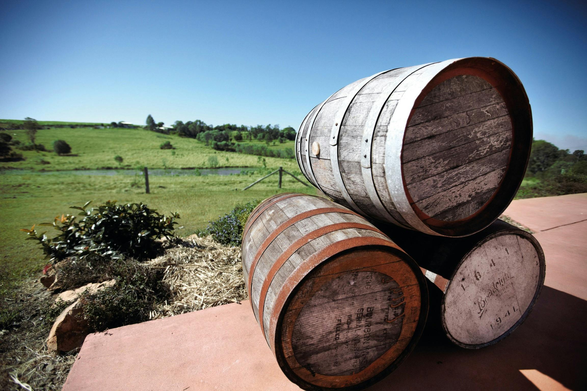 3 Wine barrels stacked at Hill of Promise winery overlooking the rolling green hills of Childers