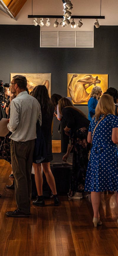 A group of people exploring the Nolan Collection at Canberra Museum + Gallery