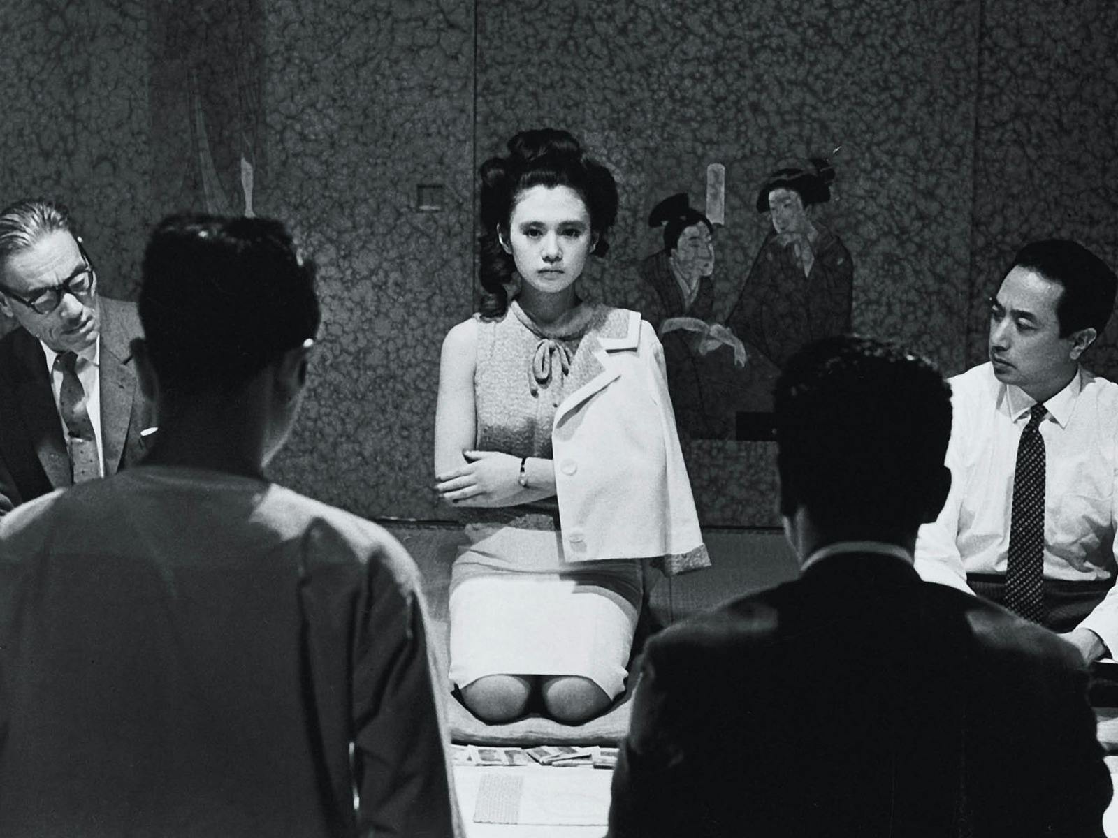 Black and white image of woman kneeling on floor with arms crossed