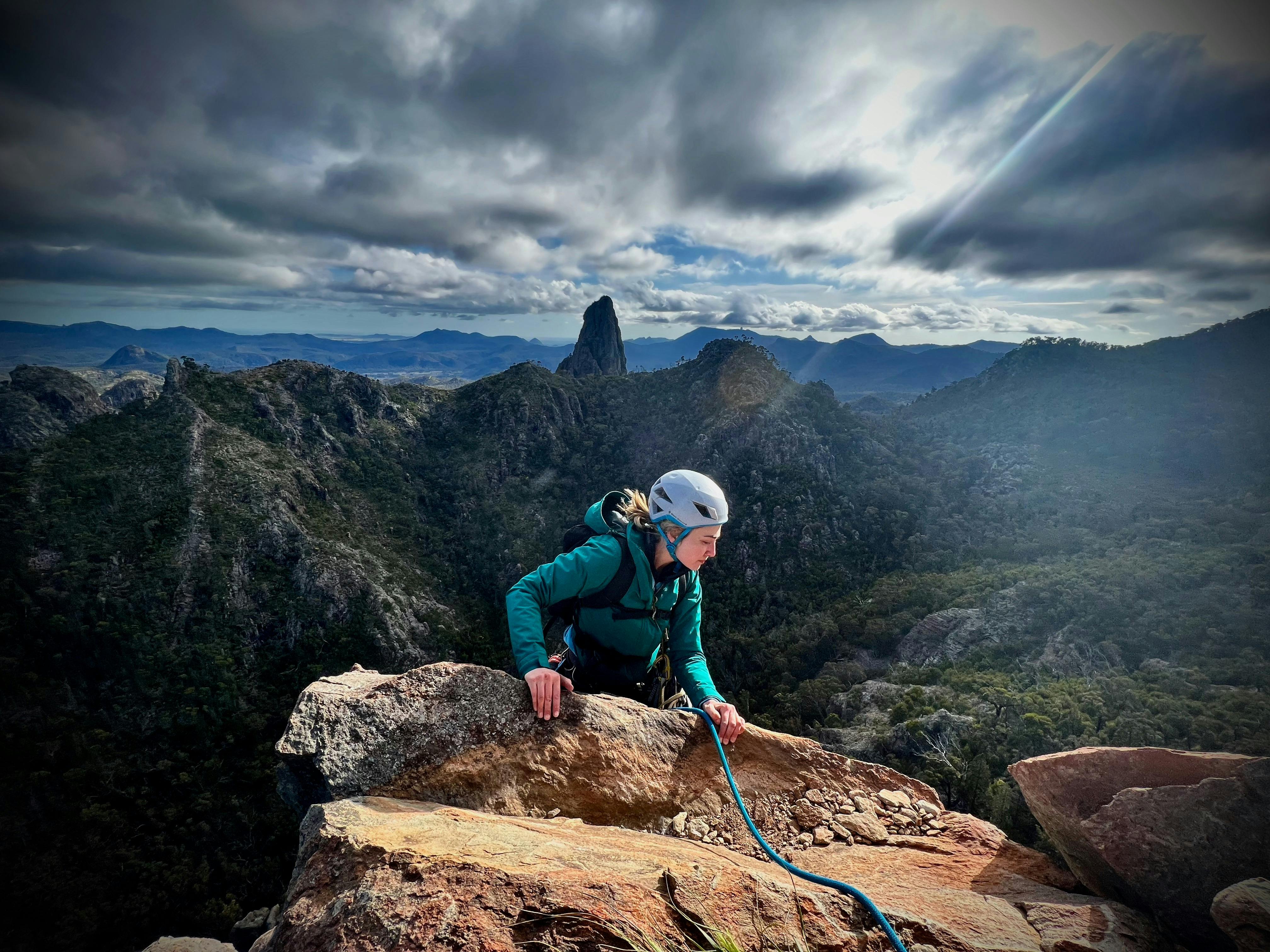 Belougery Spire를 포함한 놀라운 배경을 갖춘 난간 위로 이동하는 등반가의 모습이 포착되었습니다.