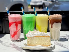 Four smoothies and a slice of cake