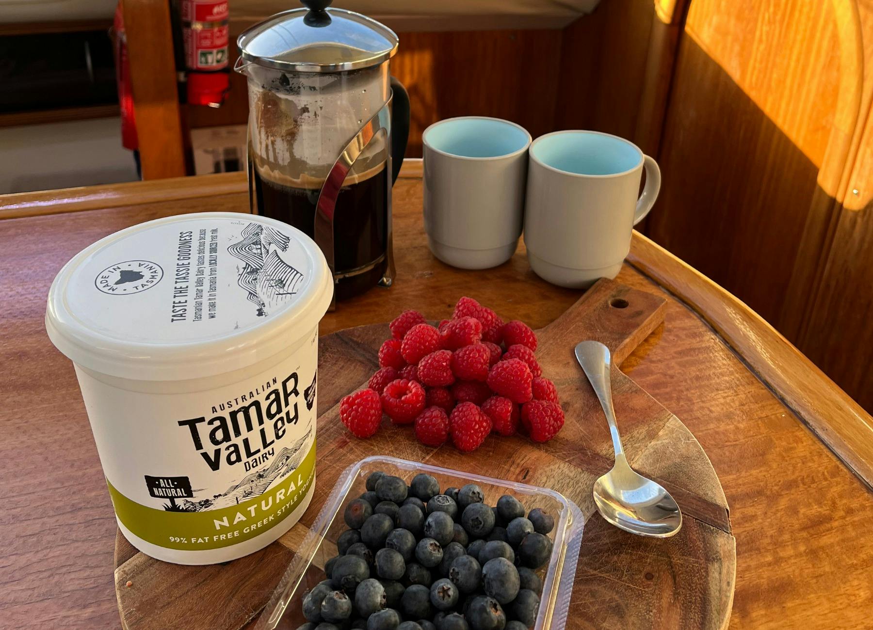 Close up photos of yoghurt and seasonal fruits with coffee for breakfast on board.
