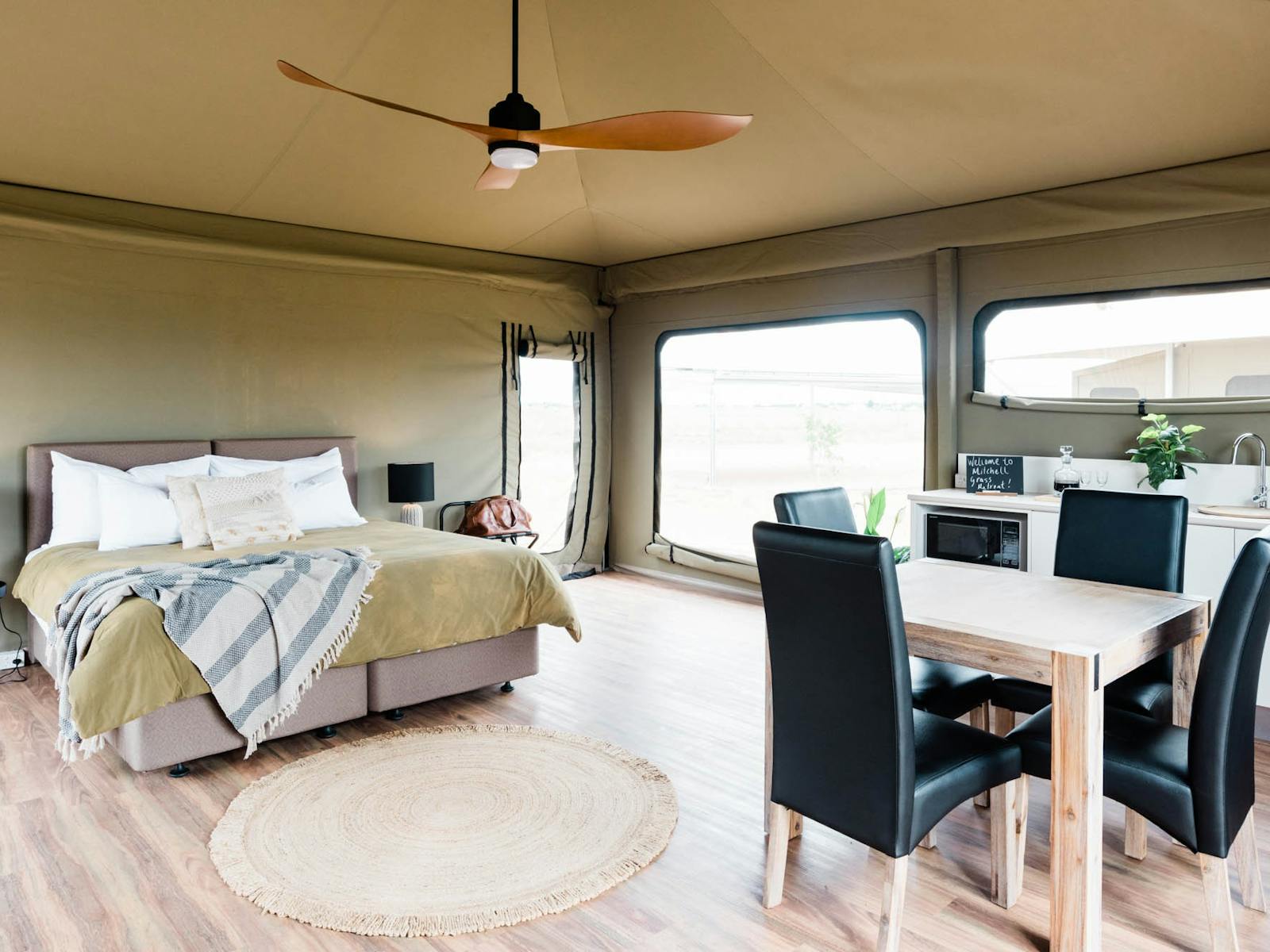 Large bed and dining table inside glamping tent Large bed and dining table inside glamping tent