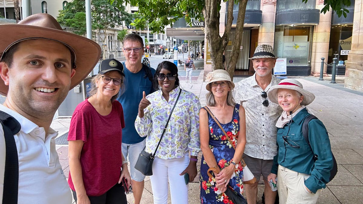 Seven people in a selfie in the street.