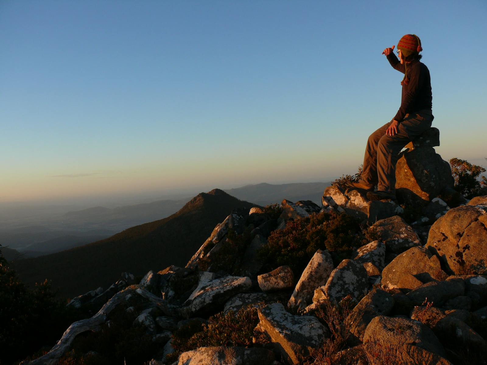 A walker sits at the summit of Collins Bonnet in Wellington Park