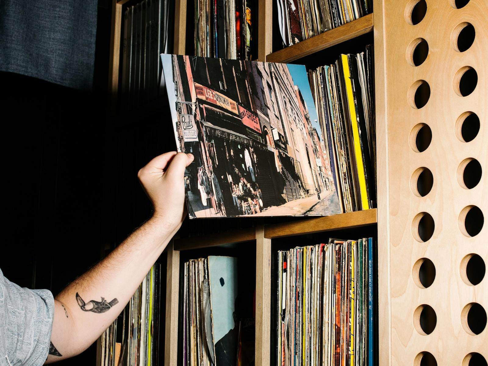 Hand taking vinyl album from shelf