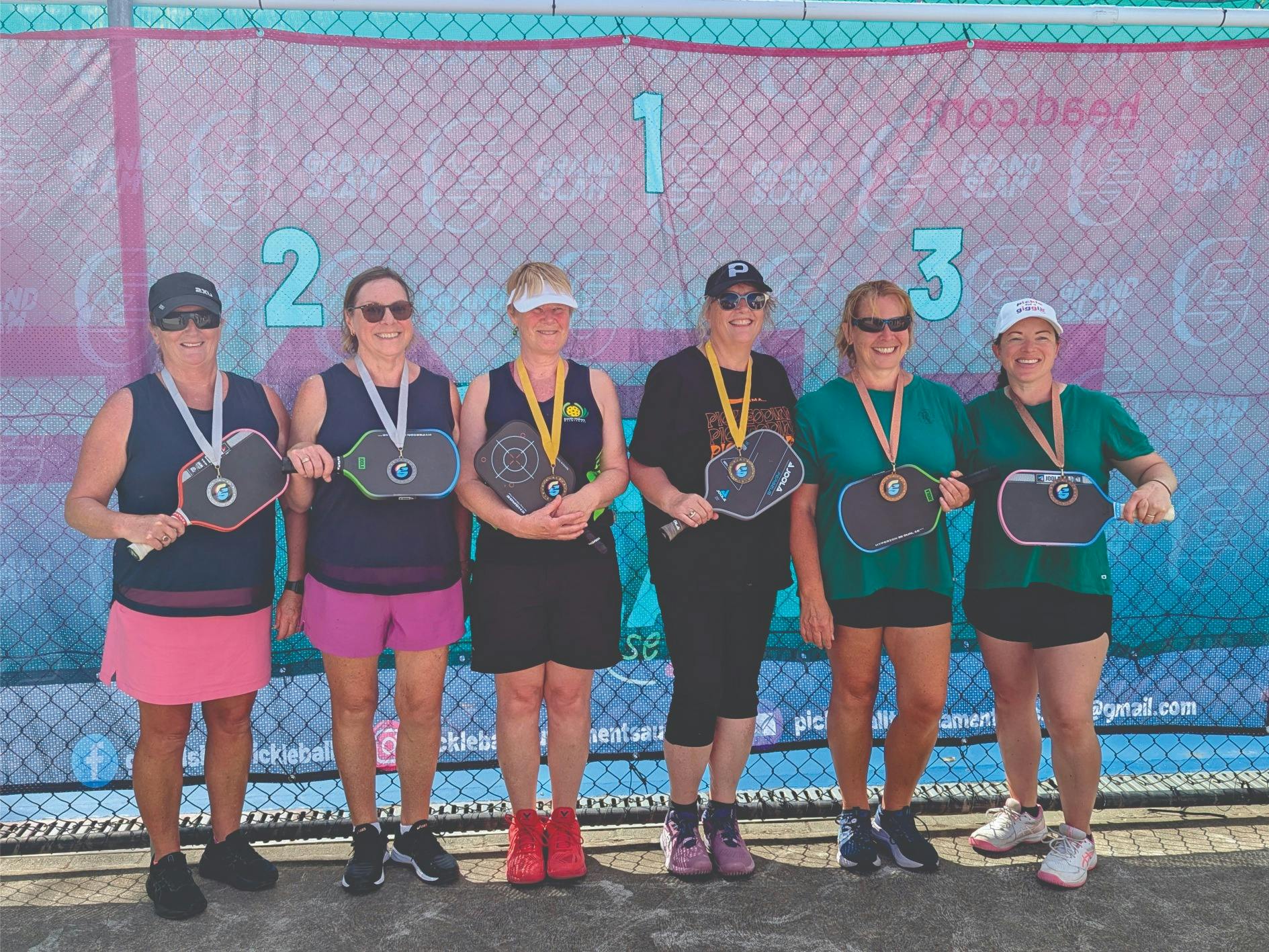 Six female pickleball players receiving medals after their event