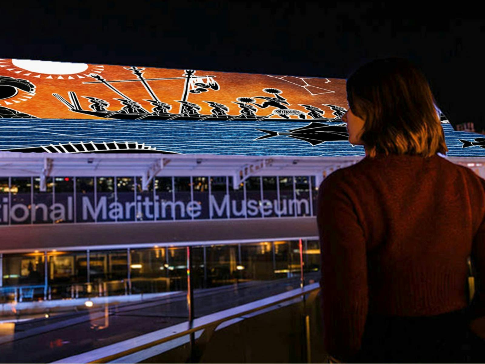 A woman views the Brian Robinson projection on the museum roof