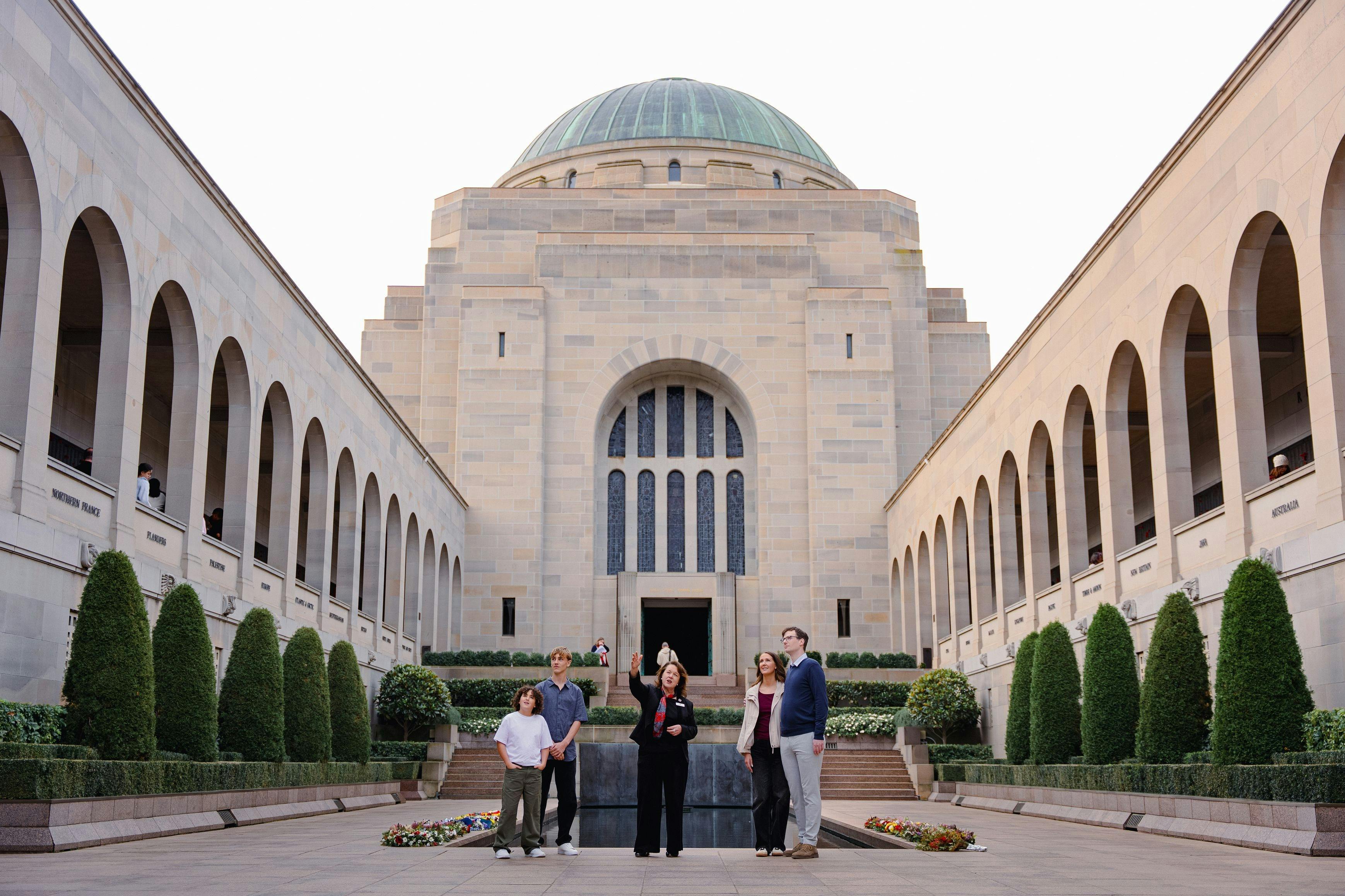 Group of visitors standing in the Commemorative Area in front of the Hall of Memory