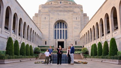 Group of visitors standing in the Commemorative Area in front of the Hall of Memory
