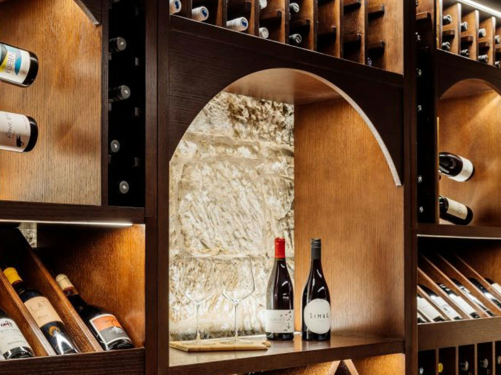 Cellar at The Tasman with wine against a sandstone backdrop