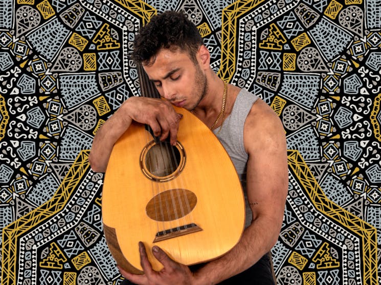 Youssef Sabet craddles a oud in a grey singlet