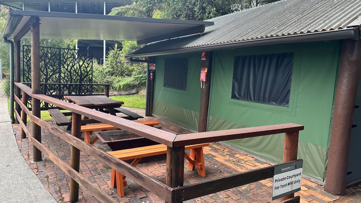 Image shows the exterior courtyard and fire pit of the Safari Tents