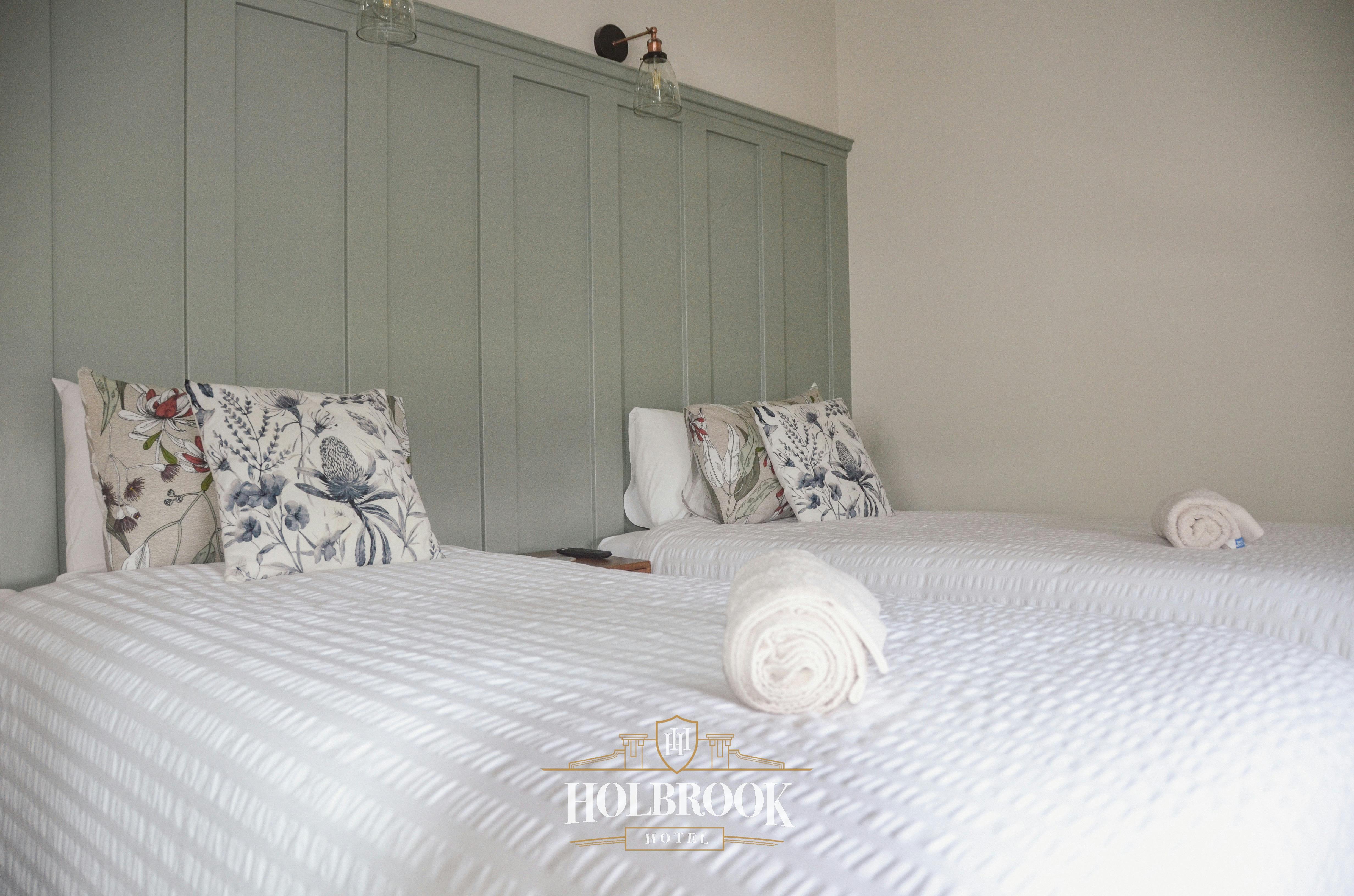 흰색 시트와 녹색 머리판을 갖춘 트윈룸