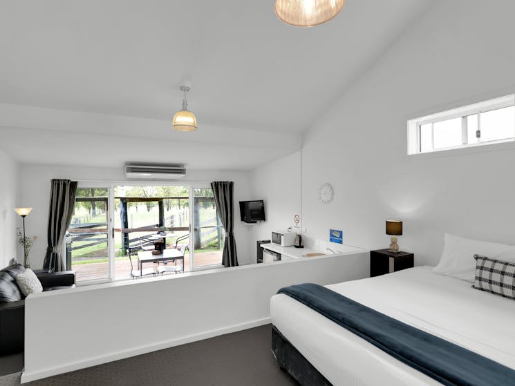 Stockyard Suite interior showing bedroom & sunken living room that opens onto veranda