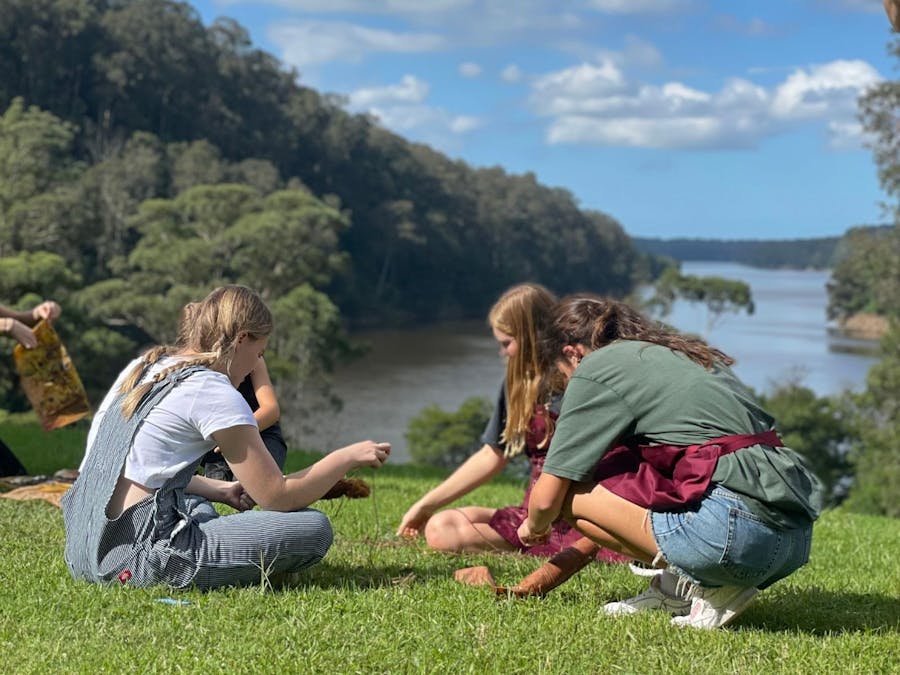 High school students completing an outdoor artmaking workshop with a view of the Shoalhaven River