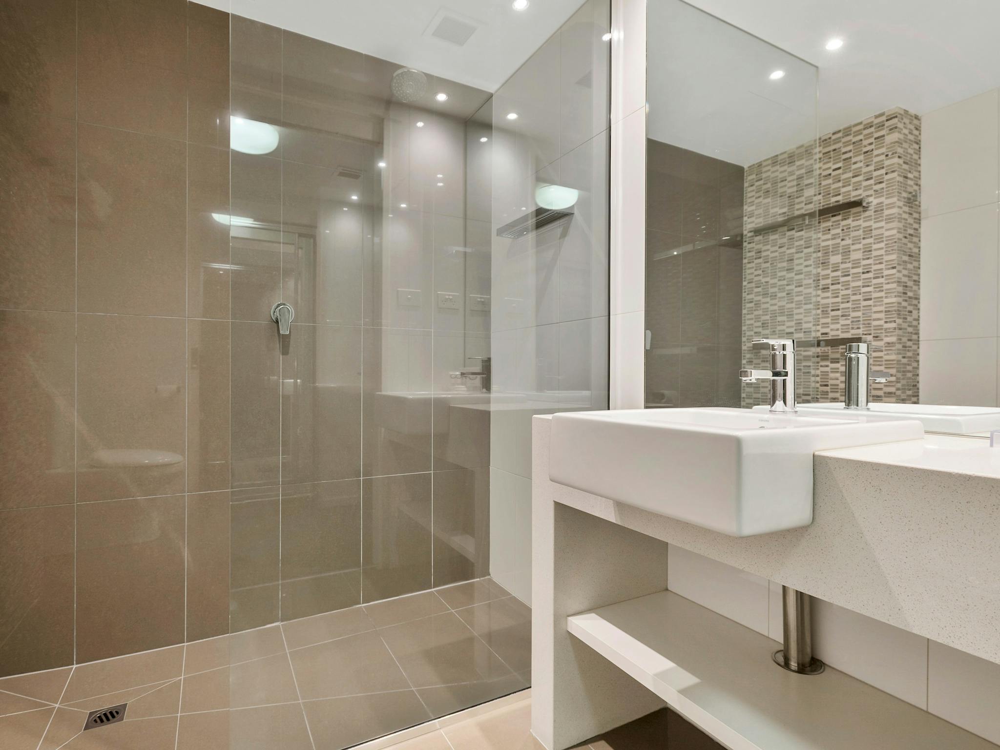 The Gateway's Family Suite Bathroom includes  large walk-in shower, toilet and vanity