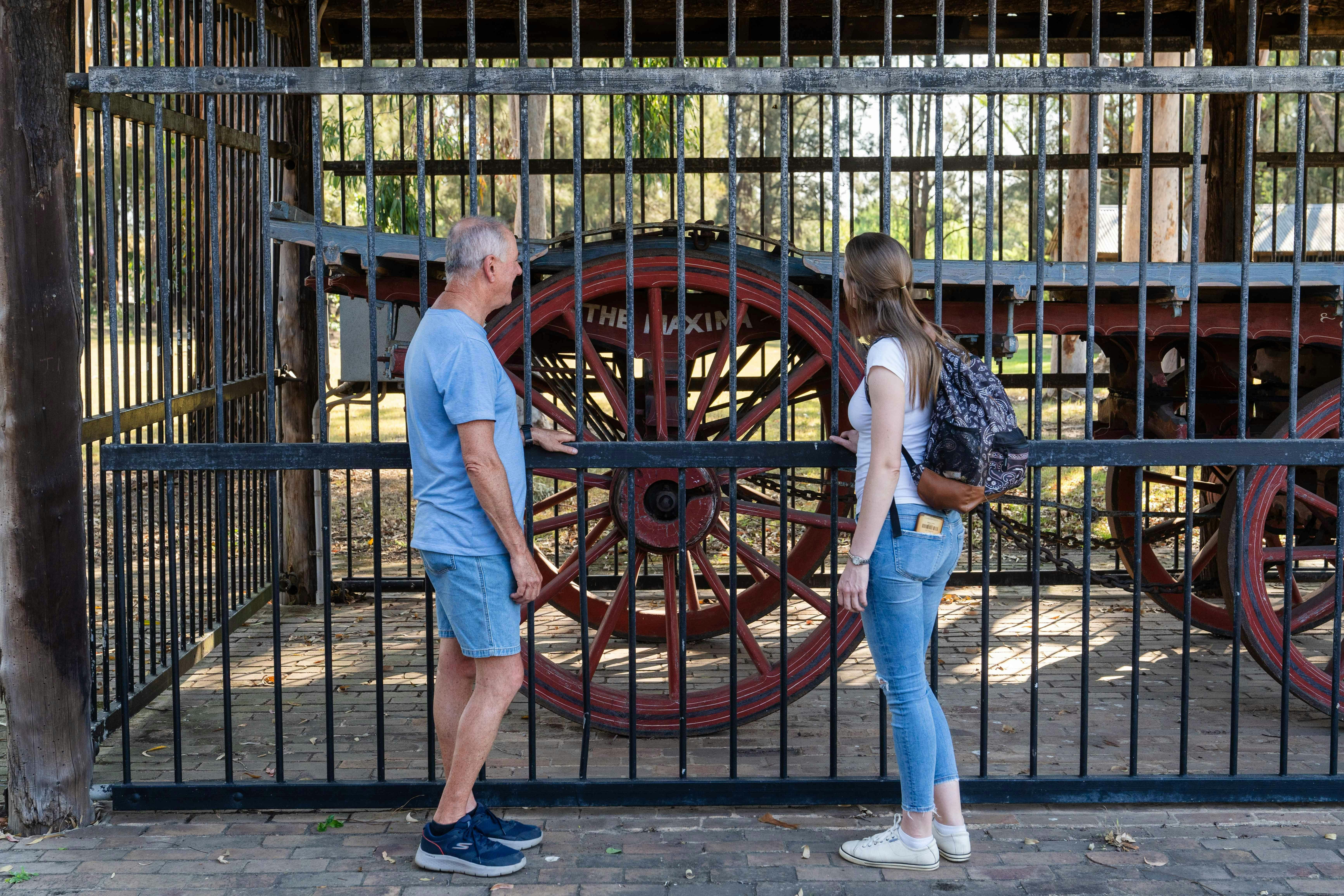 Woman and man looking at Bennett wagon in a shed