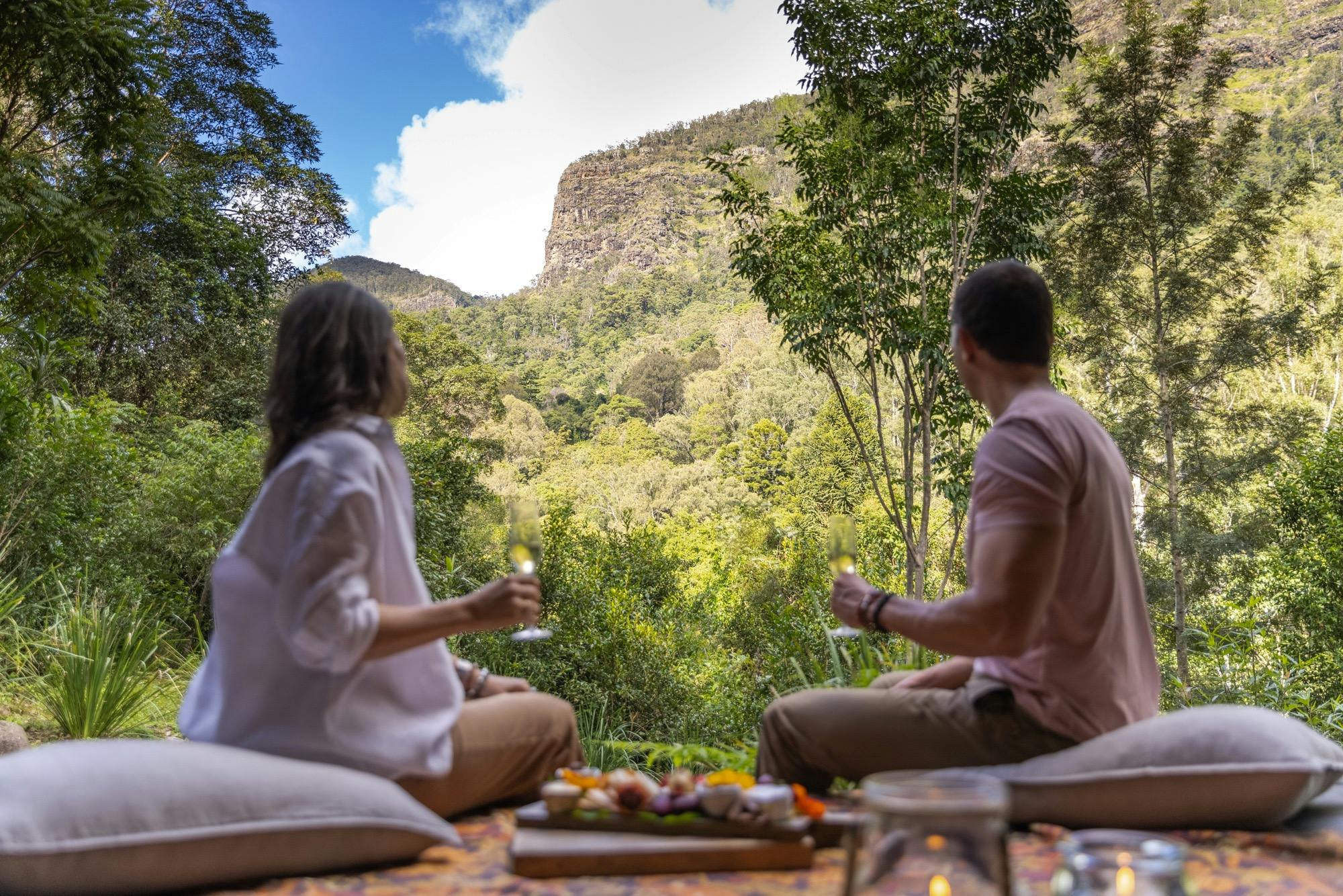 Couple enjoying a welcome platter with Australian sparkling on the deck of safari tent.