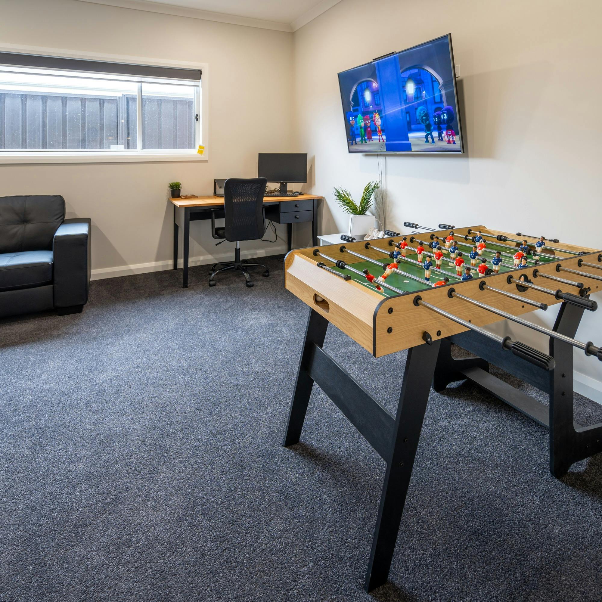 두 번째 거실에는 모니터가 딸린 책상, TV 소파 푸스볼 테이블, Nintendo Wii가 마련되어 있습니다.