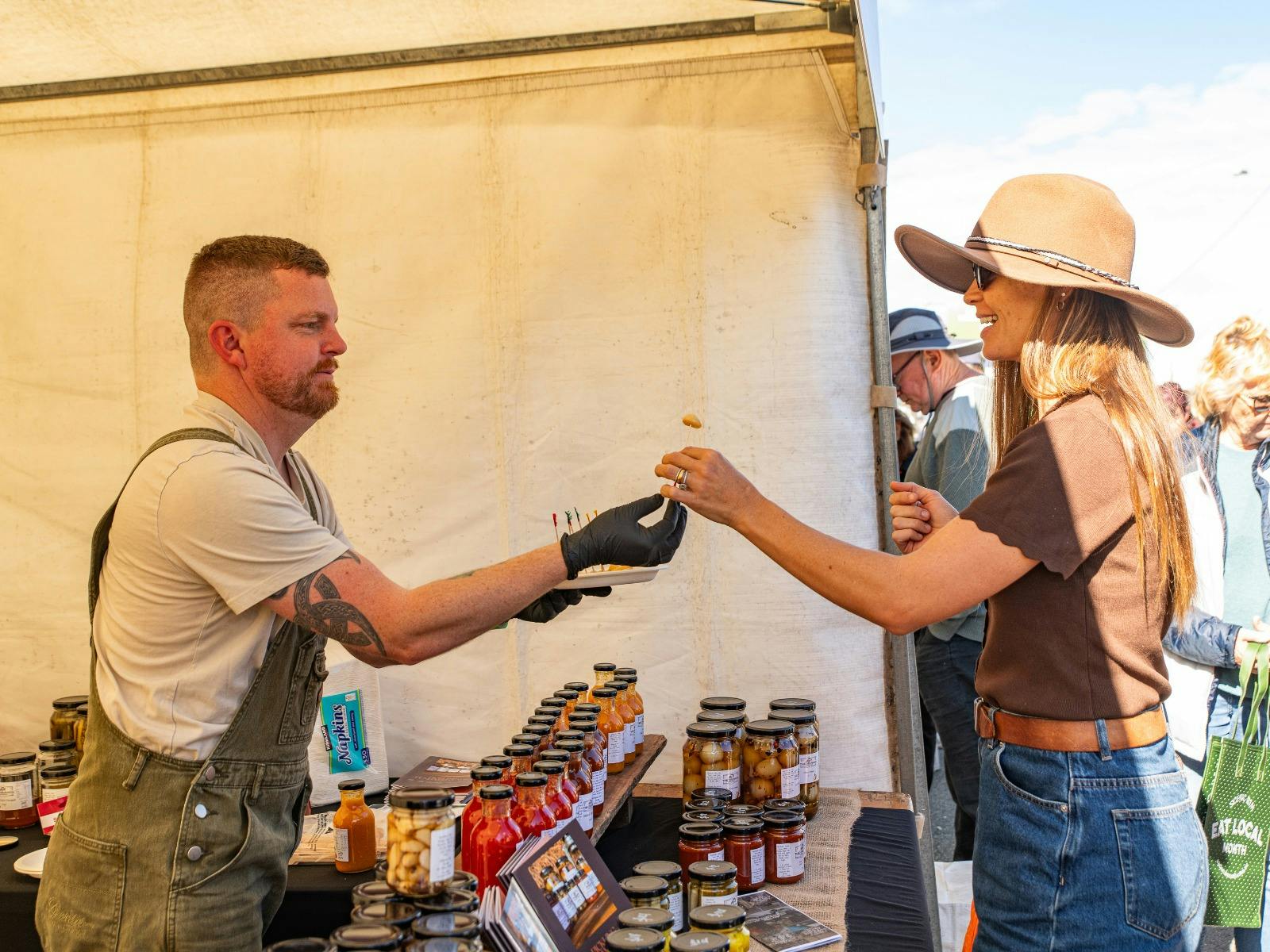 Woman enjoying a free sample tasting from stallholder at the Winter Harvest Festival