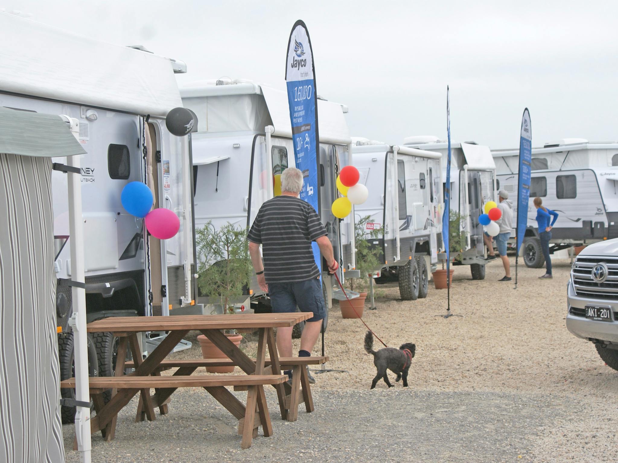 Man walking his dog through sales yard