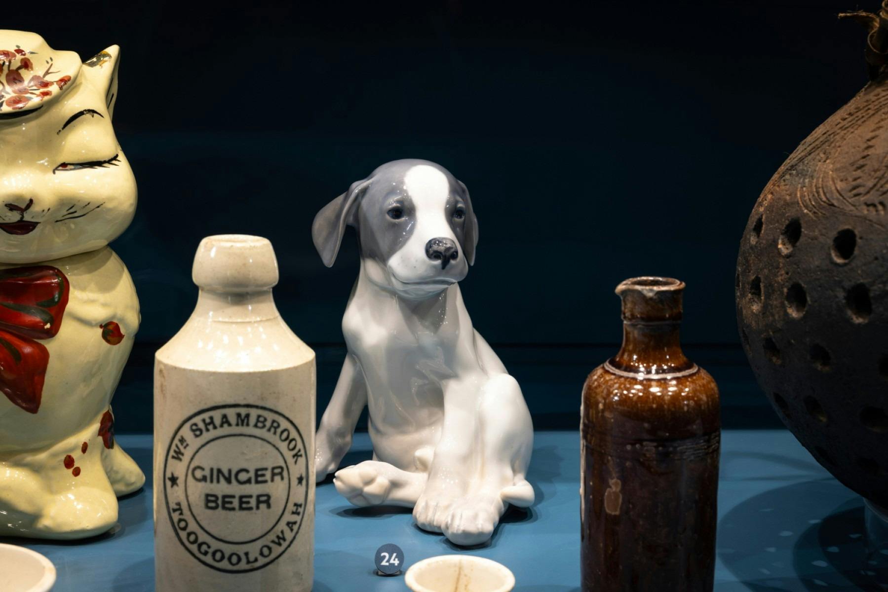 A small ceramic dog features among other ceramic objects in a display case