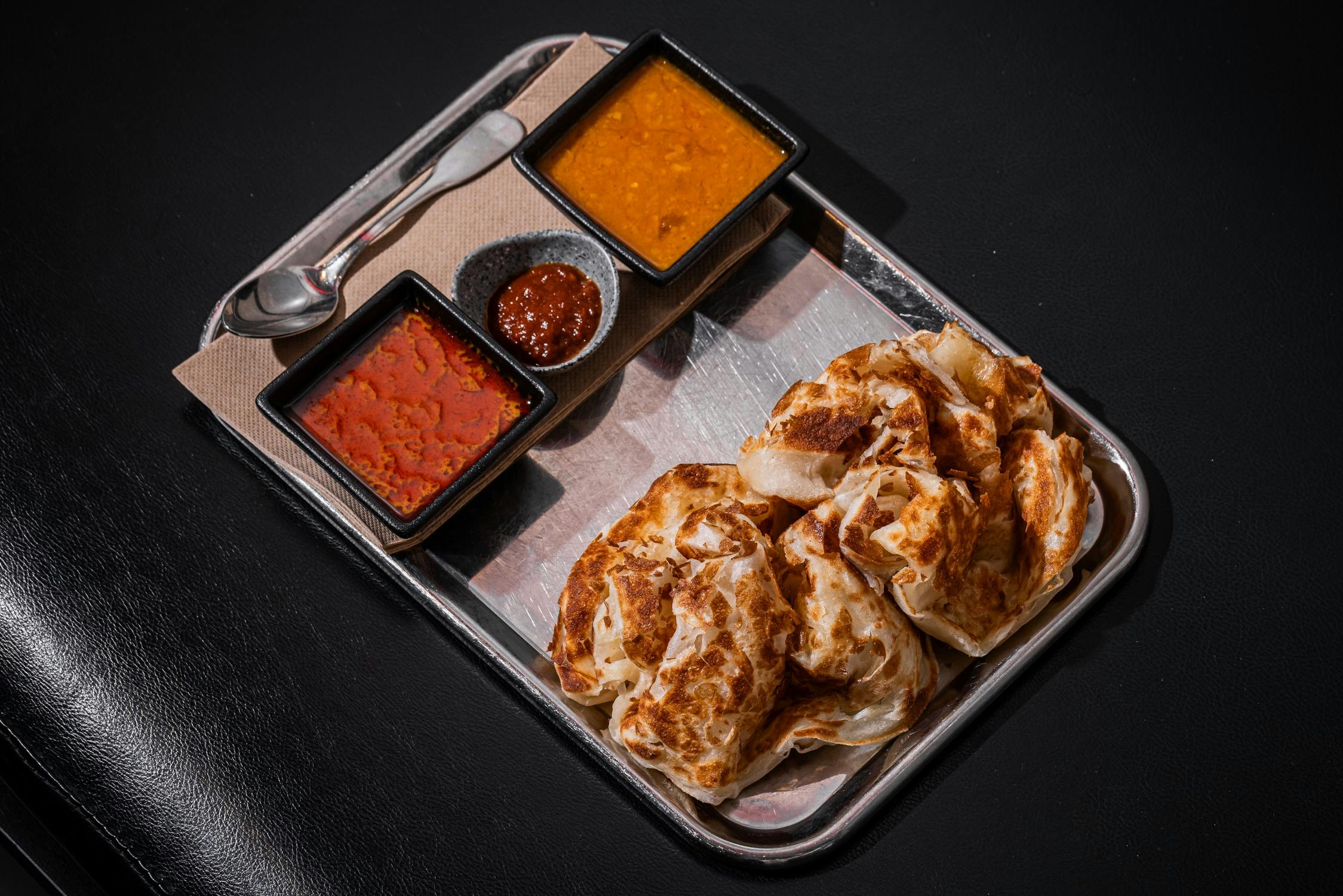 Roti served with curry gravy and sambal