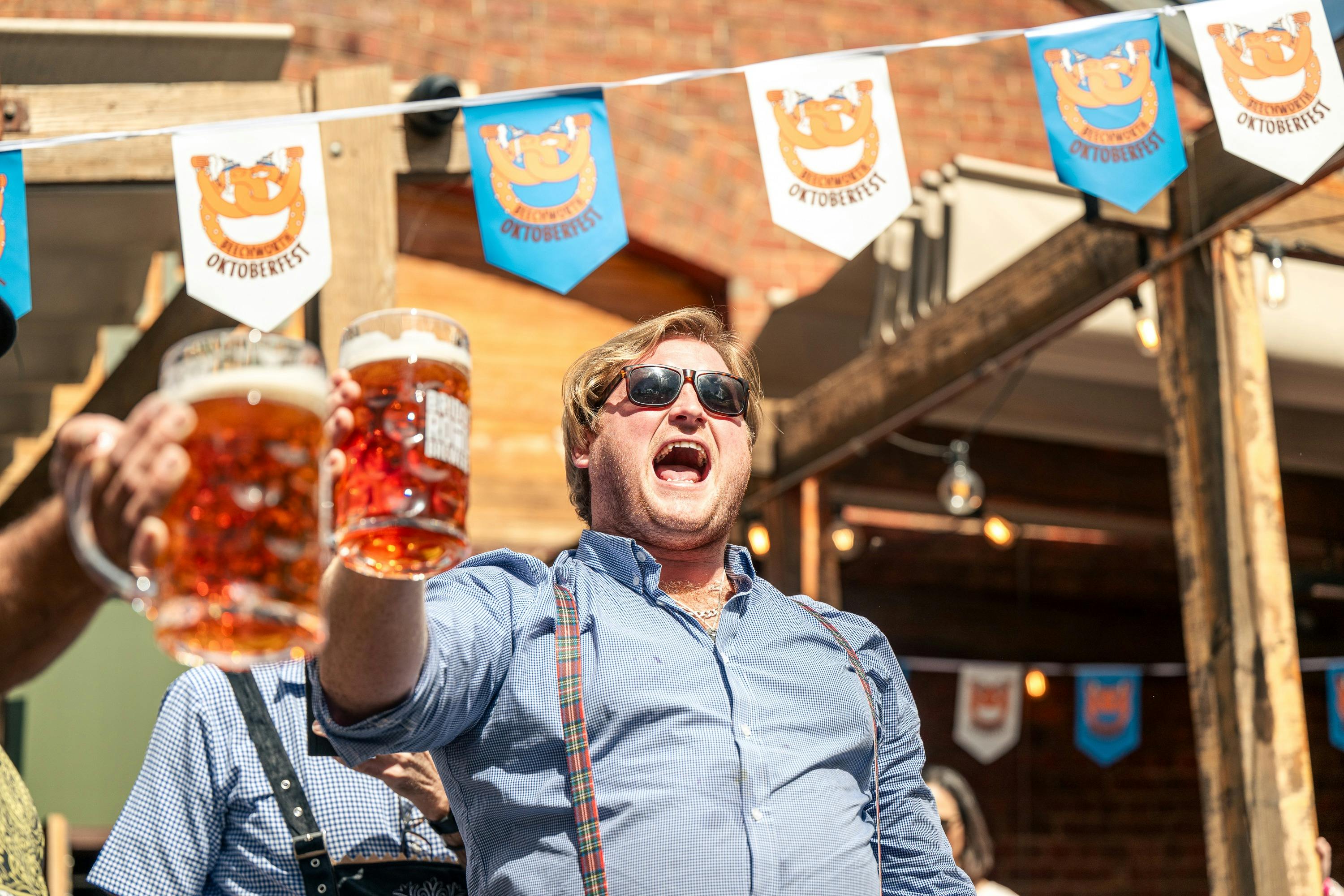 Young man yelling out to the crowd cheering with drink