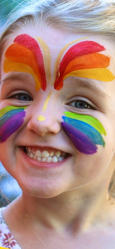 girl with face painted smiling at Family Fun Day at the Mint