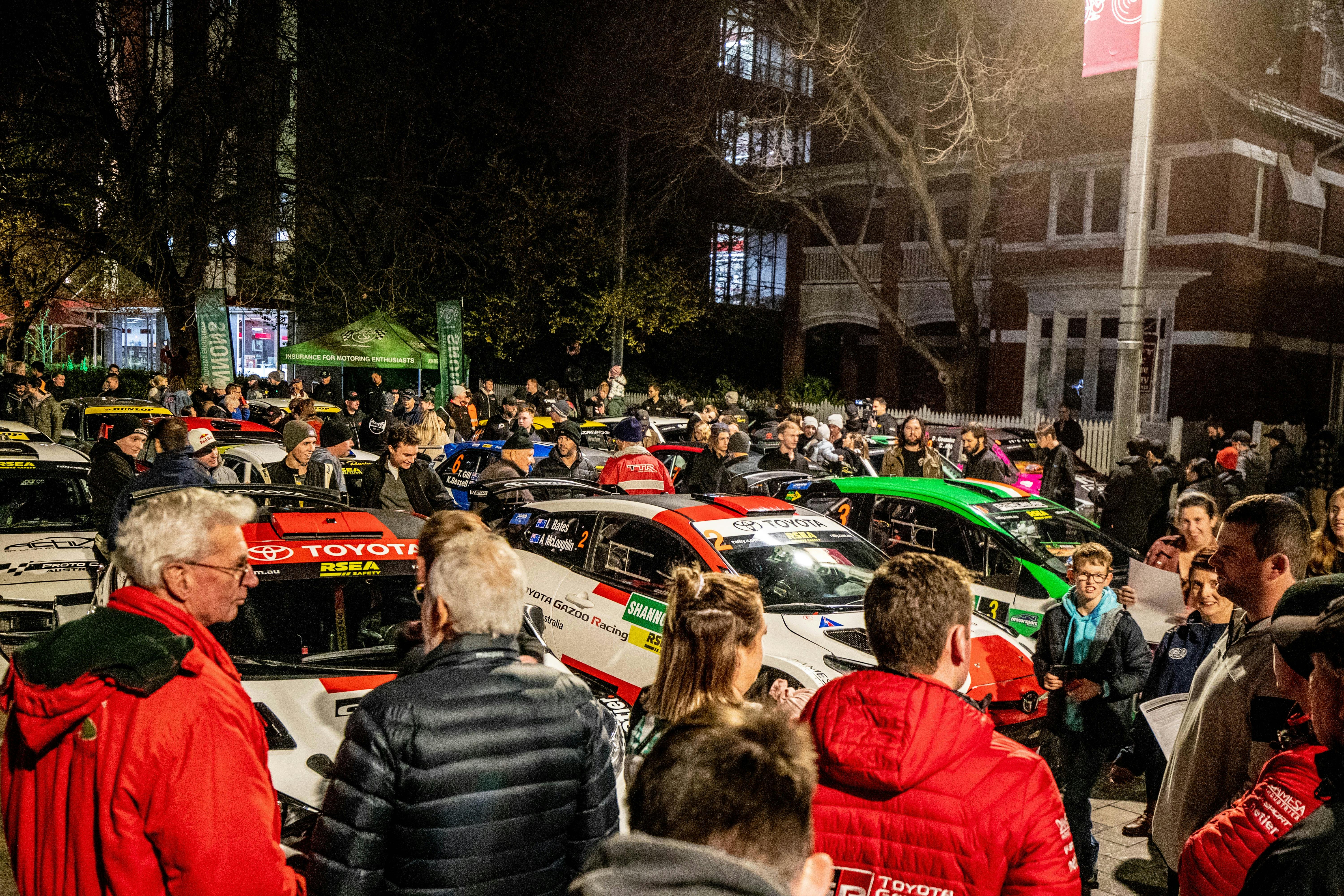 People surrounding rally cars in the city