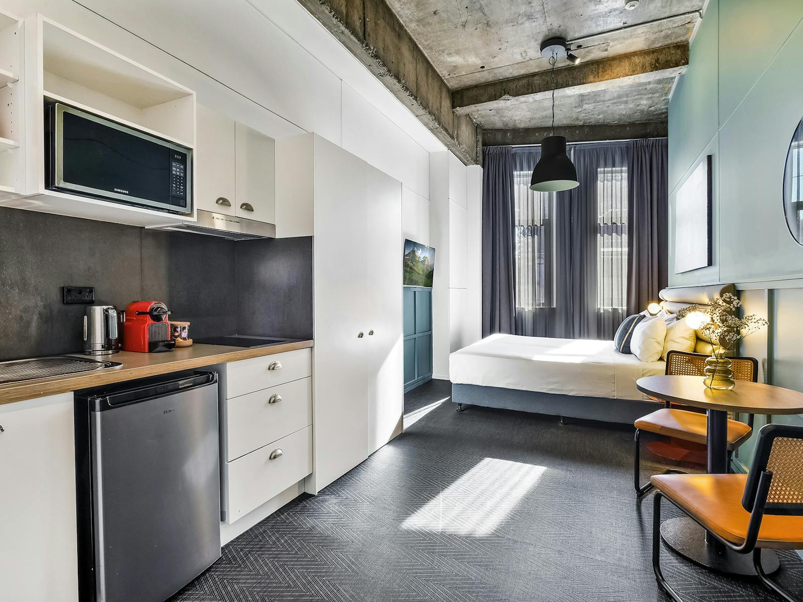 간이 주방, 2인용 테이블 창가 침대가 있는 The Urban Newtown의 스튜디오 호텔 객실