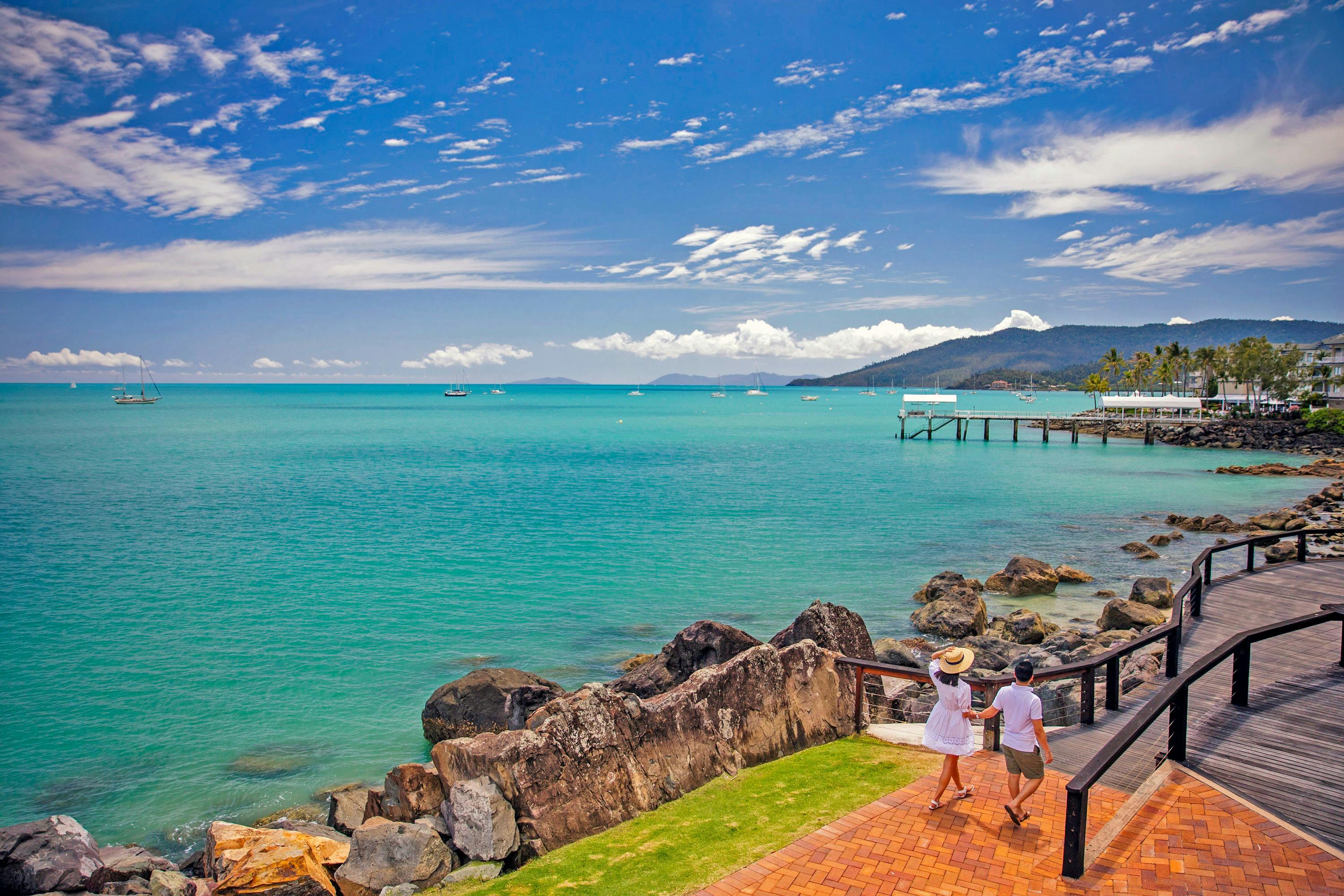 A couple walking one the scenic Bicentennial walkway along the turquoise color water