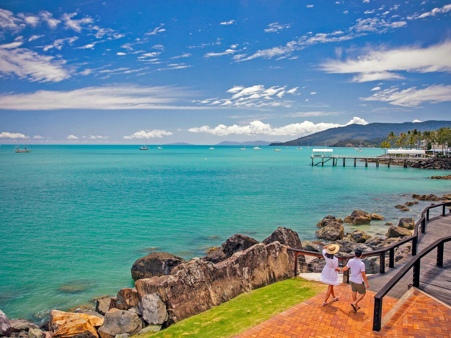 A couple walking one the scenic Bicentennial walkway along the turquoise color water