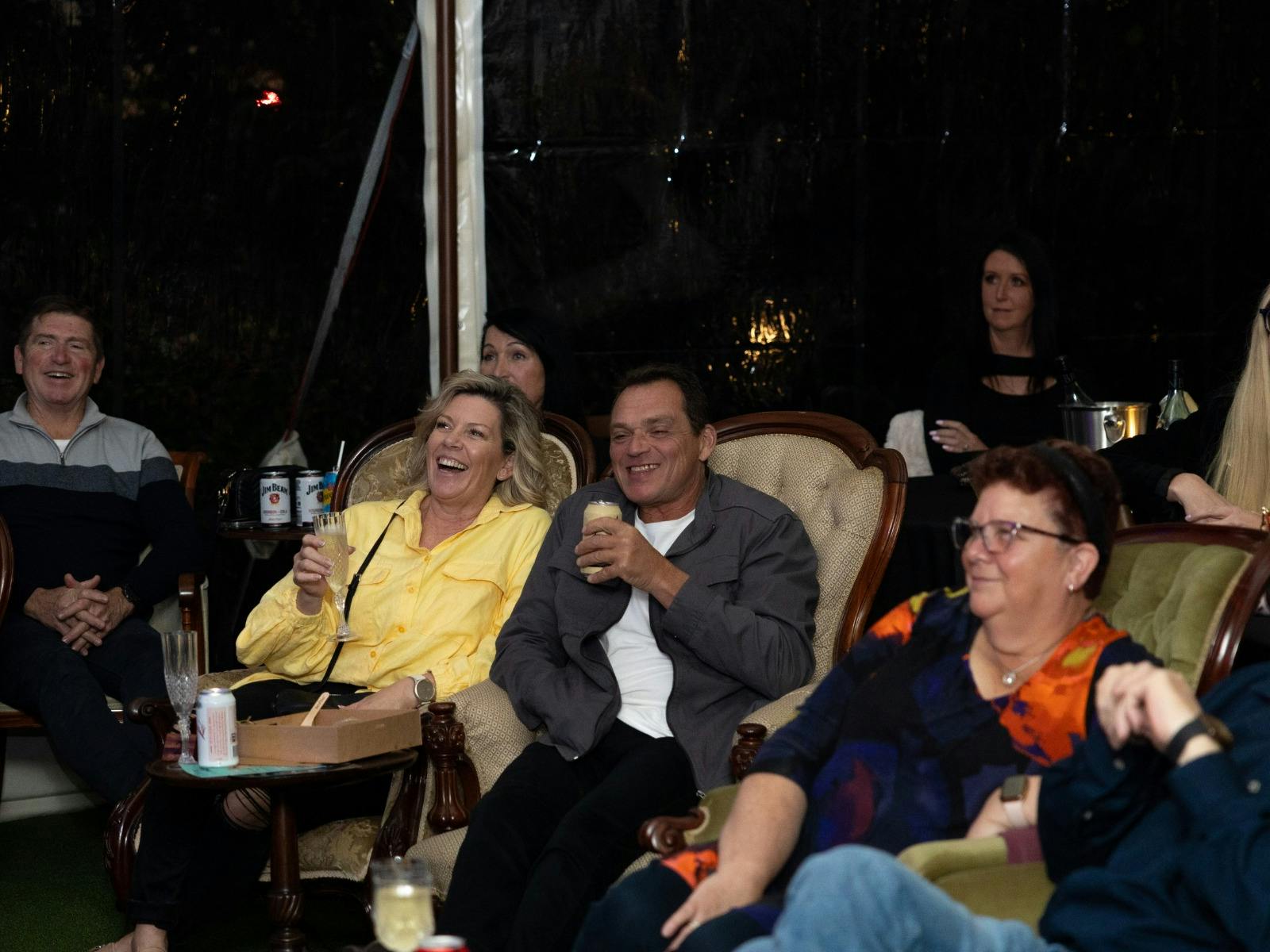 people sitting in victorian era furniture laughing nighttime