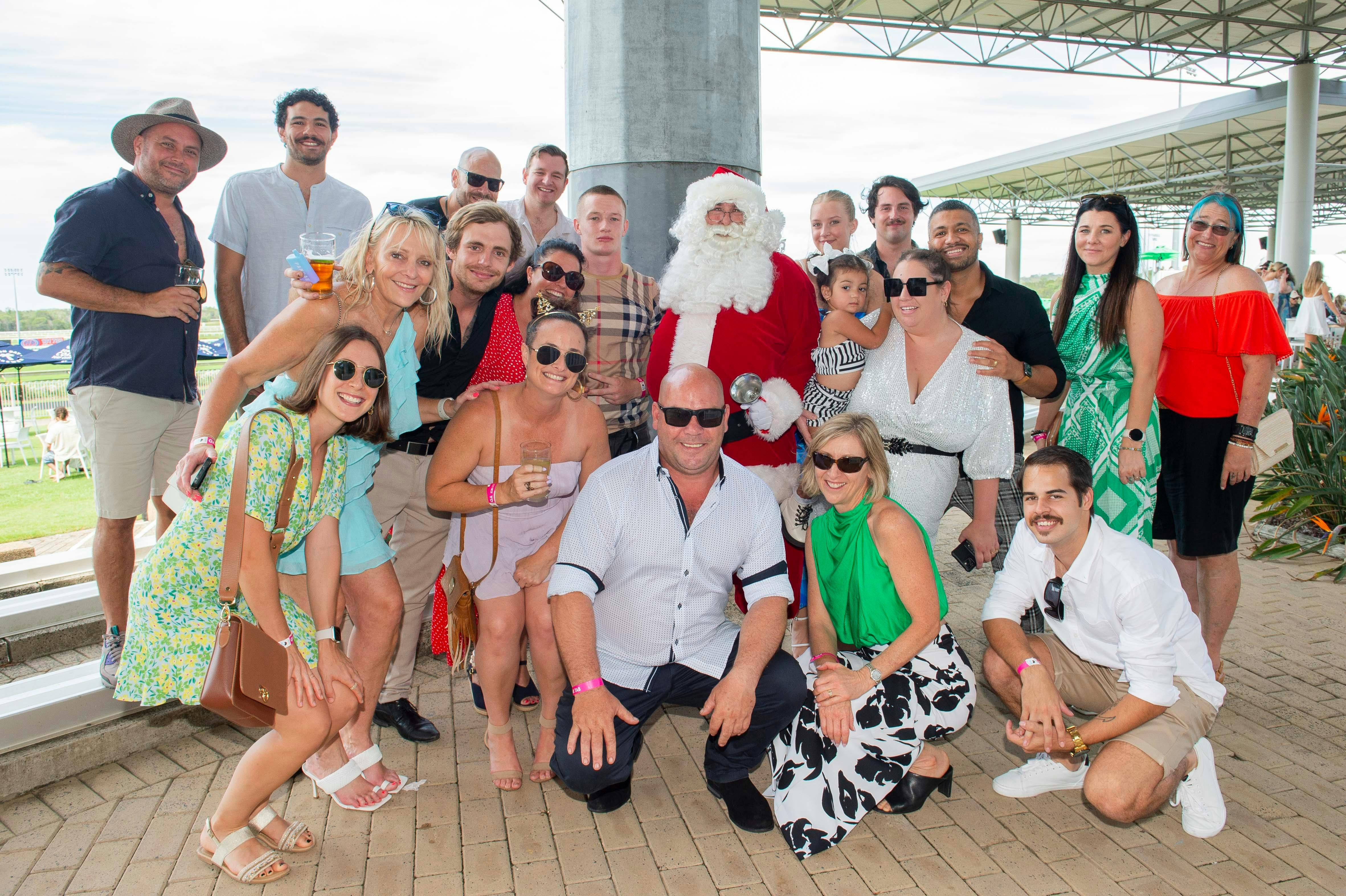 Large group of people having a Christmas party photo with Santa