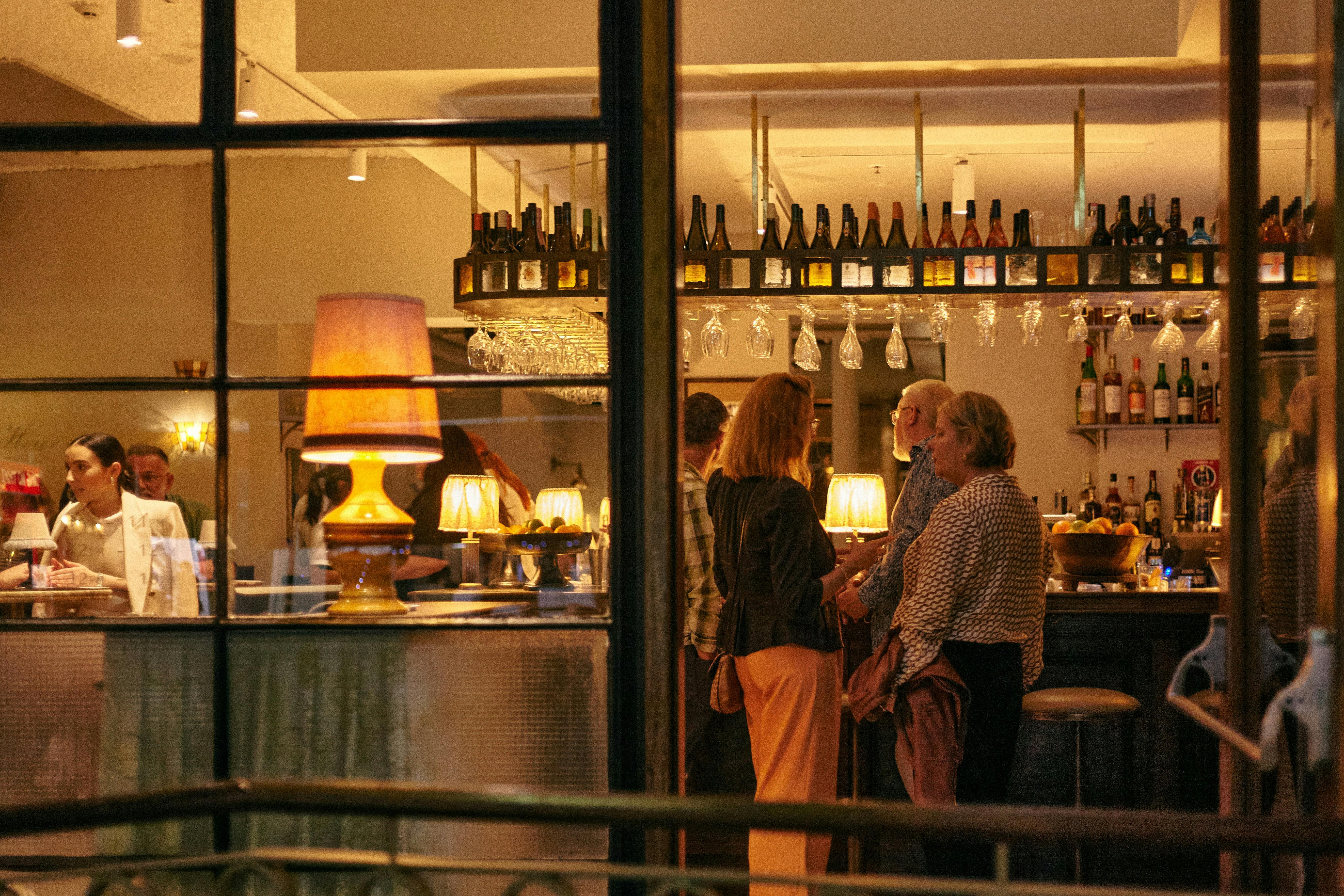 Two people standing at bar