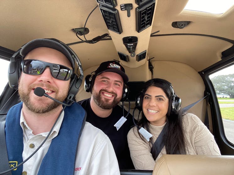 Photo of smiling passengers and pilot inside the helicopter