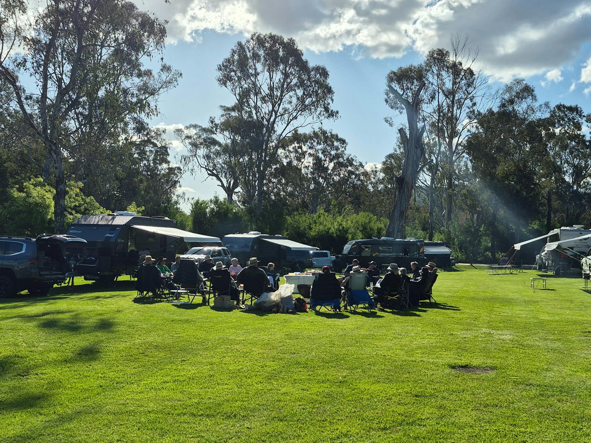 a Group of people sitting at the camp ground