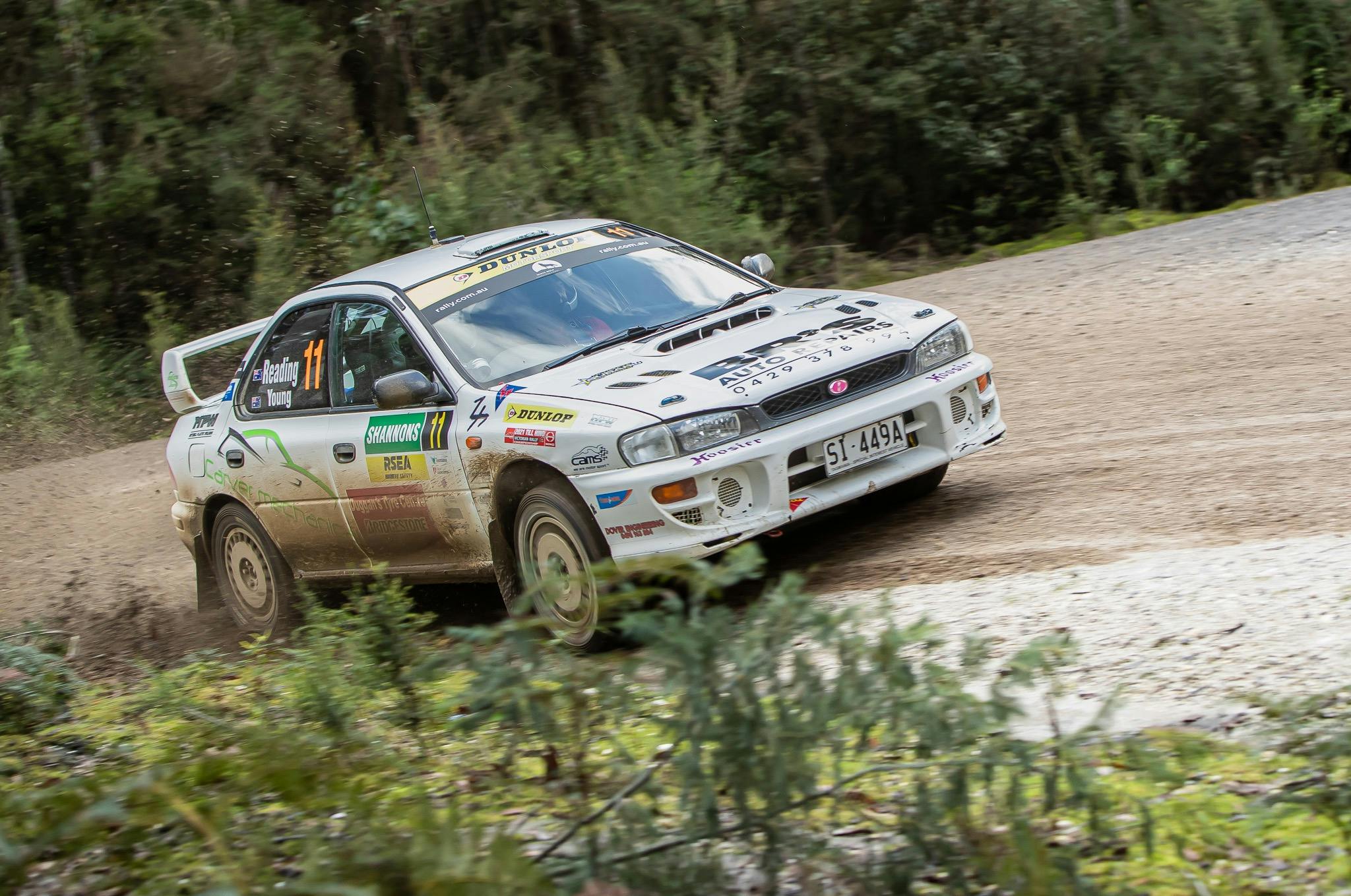 White rally car driving on a gravel road