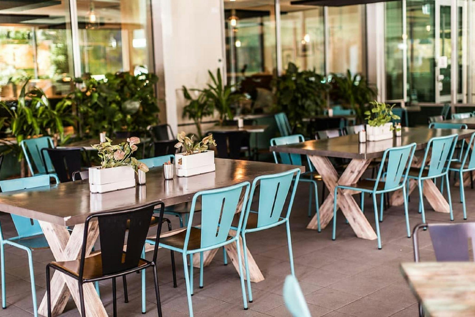 Empty outdoor tables with blue and black seating