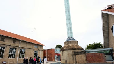 Visitors walking around large smokestack