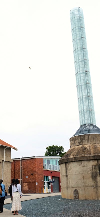 Visitors walking around large smokestack